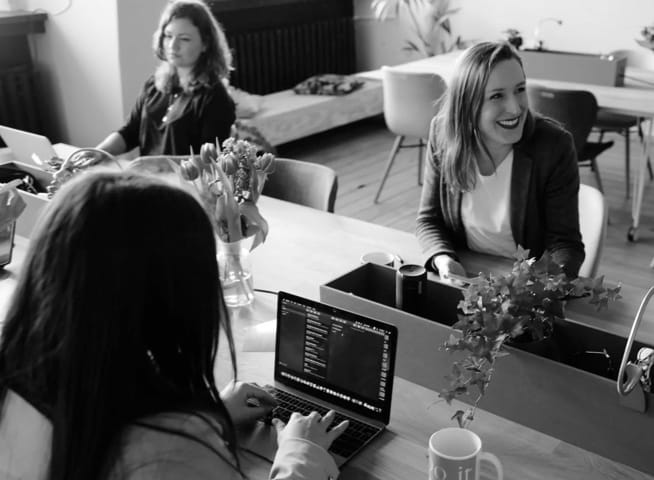 People sitting at a desk smiling and working